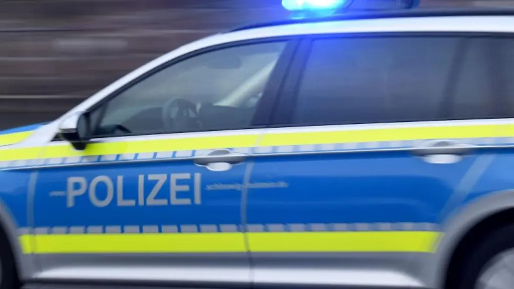 Ein-Streifenwagen-mit-eingeschaltetem-Blaulicht-faehrt-ueber-eine-Strasse