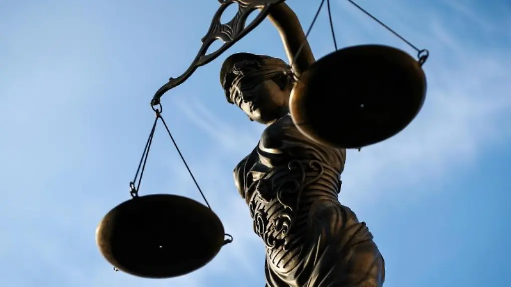 Eine-Statue-der-Justitia-haelt-eine-Waage-in-der-Hand