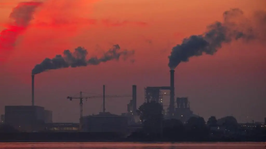 Aus-Schornsteinen-der-Holzbetriebe-an-der-Wismarbucht-steigt-vor-dem-Sonnenaufgang-Rauch-auf