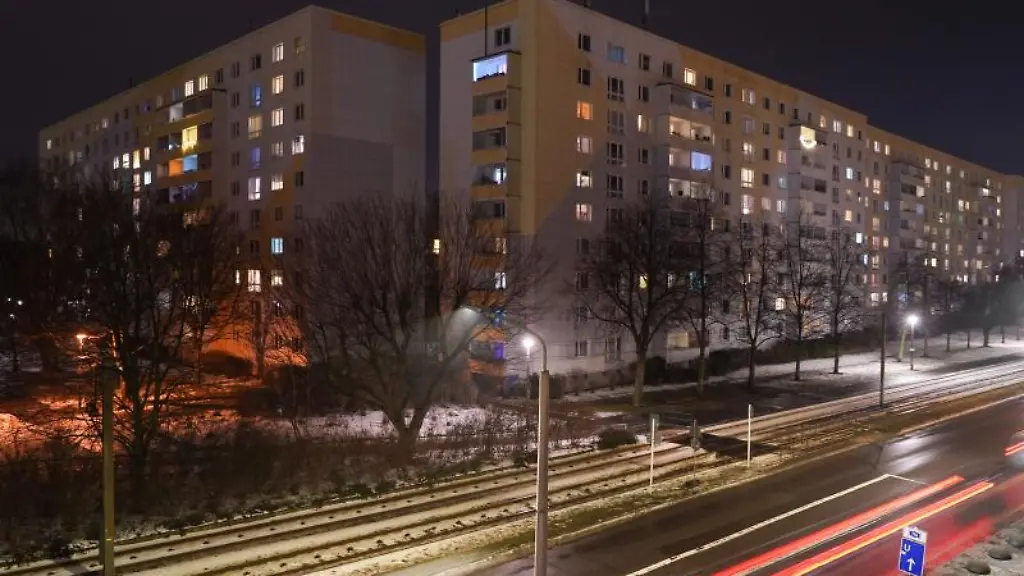 Teilweise-hell-erleuchtet-sind-einige-Zimmer-eines-Mehrfamilienhauses-am-Abend