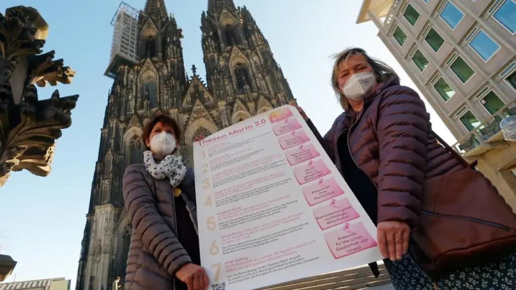 Aktivistinnen-der-katholischen-Reforminitiative-Maria-2-0-stehen-mit-einem-Thesenpapier-vor-dem-Koelner-Dom