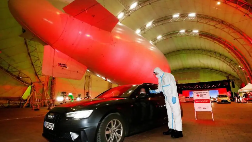 Ein-Mitarbeiter-vom-Deutschen-Roten-Kreuz-fuehrt-Corona-Tests-im-Luftschiffhangar-des-Flughafens-Essen-Muelheim-durch