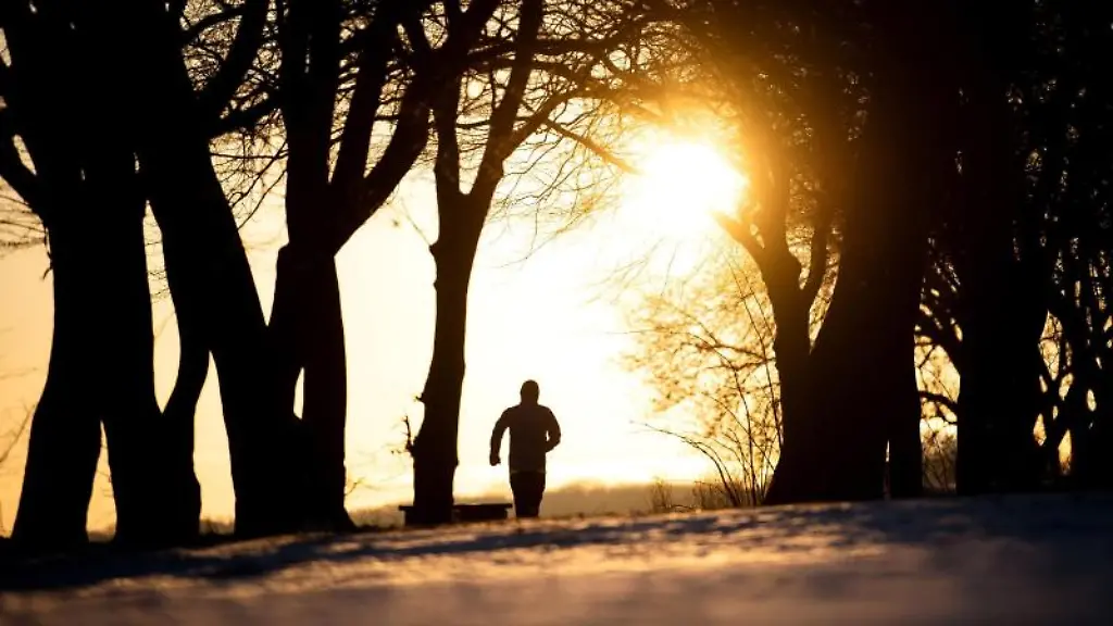 Ein-Jogger-laeuft-bei-Sonnenaufgang