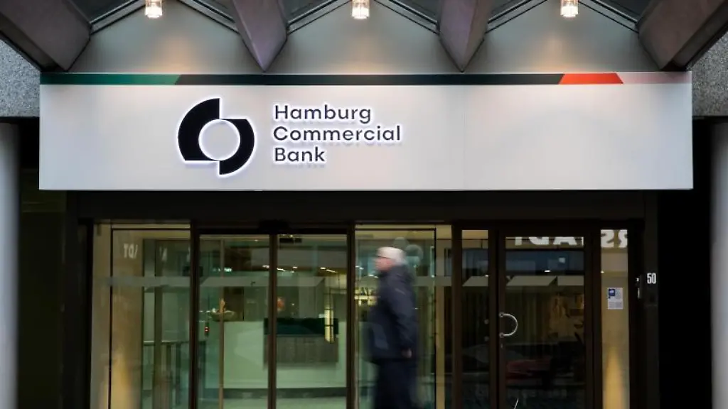 Passanten-gehen-am-Haupteingang-der-Zentrale-der-Hamburg-Commercial-Bank-vorbei