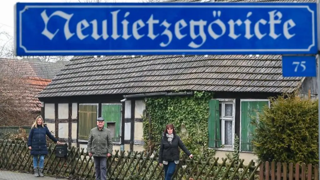 Die-Einwohner-Ramona-Schubert-l-r-Horst-Wilke-und-Martina-Herrlich-Gryzan-stehen-vor-einem-alten-Fachwerkhaus-im-Oderbruch-Doerfchen-Neulietzegoericke