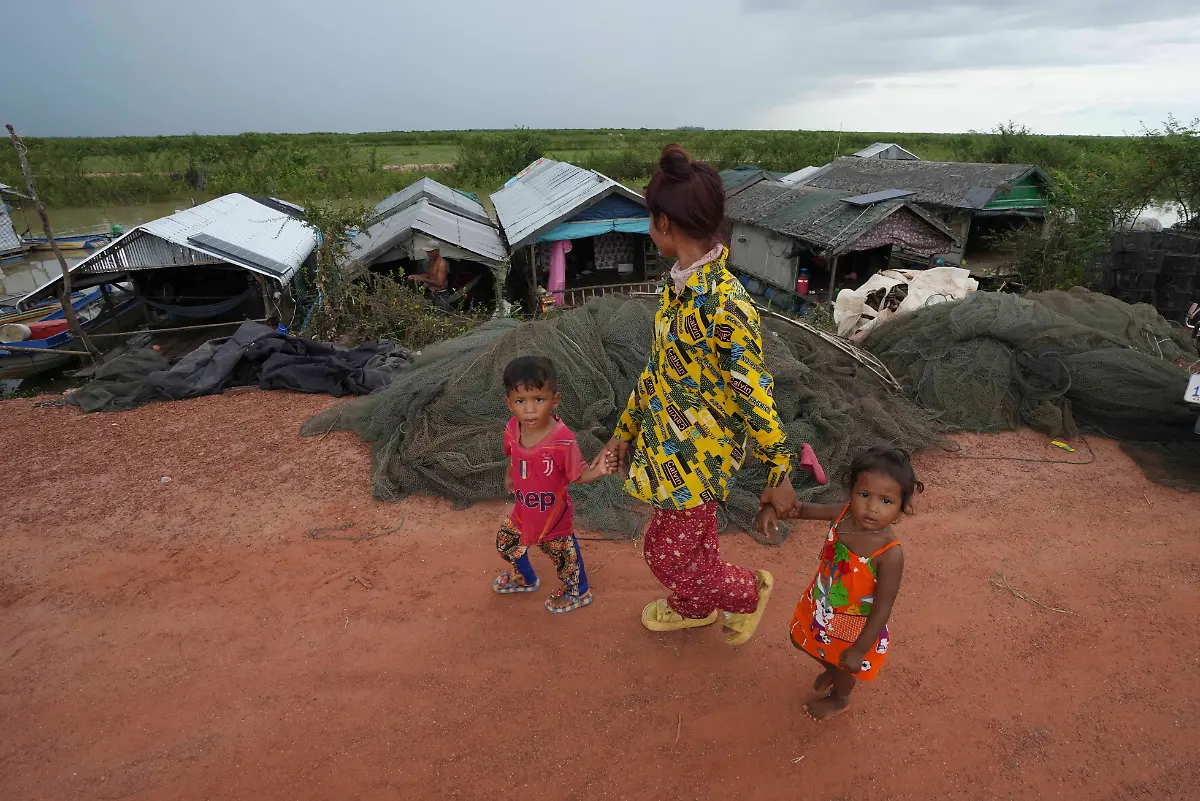 Children-walk-past-a-floating-village-by-the-Tonle-Sap-in-Kampong-Chhnang-province-Cambodia-Thursday-Aug