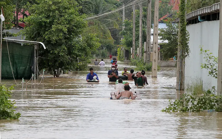 201015-PHNOM-PENH-Oct-15-2020-Xinhua-People-walk-through-a-flooded-street-in-Dangkor-district-in-the-Southwestern-suburb-of-Phnom-Penh-Cambodia-on-Oct-15-2020-Thirteen-people-have-been-killed-and-12-376-others-evacuated-in-Cambodia-after-a-tropical-storm-triggered-rains-caused-flash-floods-in-19-of-the-kingdom-s-25-cities-and-provinces-a-spokesman-said-on-Thursday