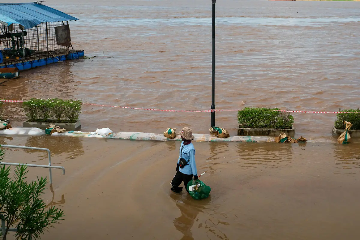 PHNOM-PENH-CAMBODIA-SEPTEMBER-30-A-person-walks-through-the-floodwaters-of-the-Mekong-River-which-has-overflowed-sharply-due-to-heavy-rainfall-caused-by-Storm-Bualoi-in-Phnom-Penh-Cambodia-on-September-30-2025-Flooding-from-continuous-rainfall-has-impacted-21-357-families-across-Cambodia-forcing-over-1-000-evacuations-and-inundating-nearly-13-000-hectares-of-rice-fields-more-than-280-km-of-rural-roads-90-schools-and-15-health-facilities