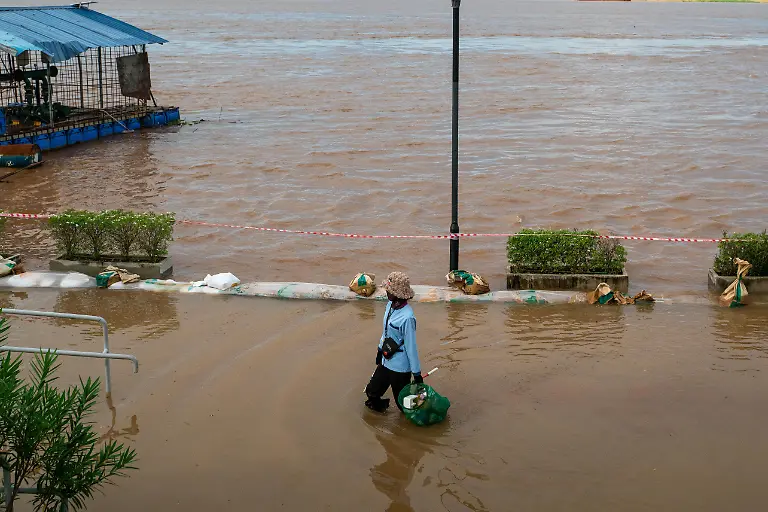 PHNOM-PENH-CAMBODIA-SEPTEMBER-30-A-person-walks-through-the-floodwaters-of-the-Mekong-River-which-has-overflowed-sharply-due-to-heavy-rainfall-caused-by-Storm-Bualoi-in-Phnom-Penh-Cambodia-on-September-30-2025-Flooding-from-continuous-rainfall-has-impacted-21-357-families-across-Cambodia-forcing-over-1-000-evacuations-and-inundating-nearly-13-000-hectares-of-rice-fields-more-than-280-km-of-rural-roads-90-schools-and-15-health-facilities