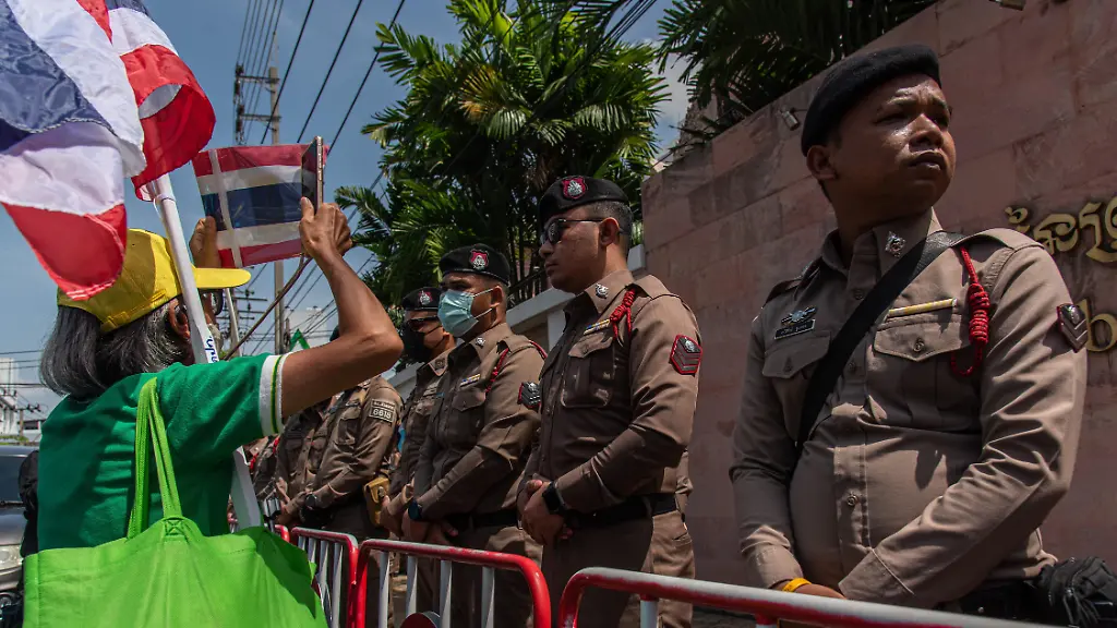A-protester-holds-a-Thai-national-flag-next-to-police-officers-during-the-protest-over-the-Thailand-Cambodia-border-conflict-The-Thai-nationalist-protesters-gathered-outside-the-Cambodian-Embassy-to-protest-over-the-border-dispute-with-Cambodia-demanding-for-action-of-Thailand-government-against-the-Thailand-Cambodia-border-conflict-after-the-clash-between-Thailand-and-Cambodia-troops-at-the-border