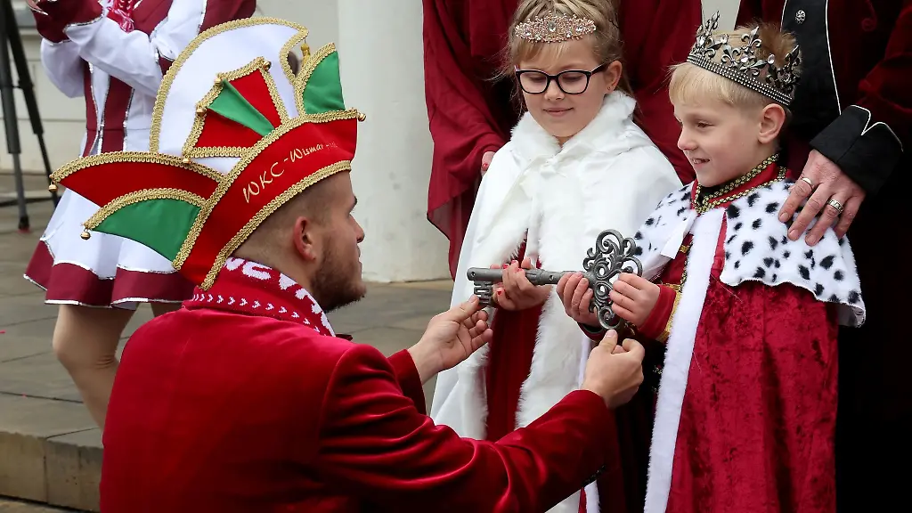 Beim-landesweiten-Auftakt-der-Karnevalssaison-in-Mecklenburg-Vorpommern-nimmt-das-Kinderprinzenpaar-vor-dem-Rathaus-der-Hansestadt-Wismar-symbolisch-den-Rathausschluessel-entgegen