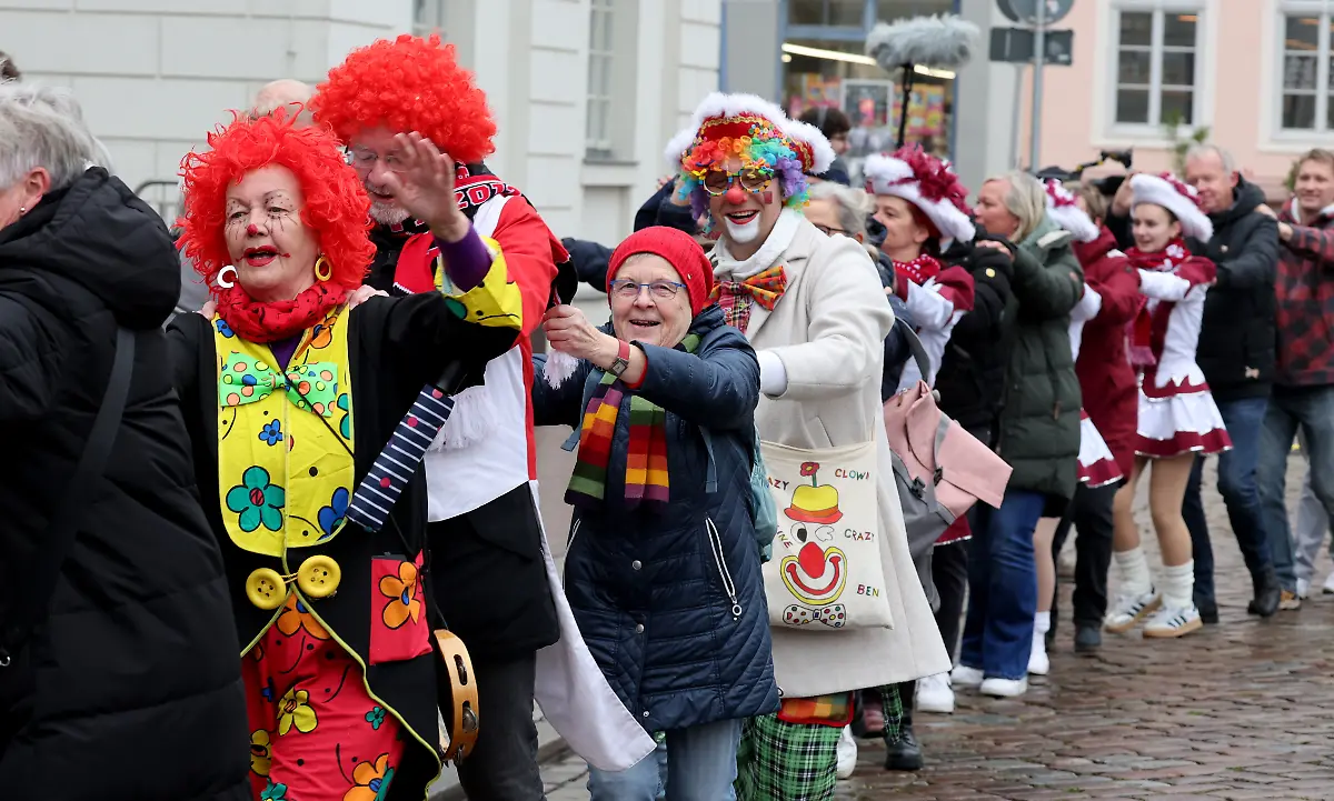Beim-landesweiten-Auftakt-der-Karnevalssaison-in-Mecklenburg-Vorpommern-zieht-eine-Polonaise-ueber-den-Marktplatz-vor-dem-Rathaus-bevor-die-Narren-symbolisch-den-Rathausschluessel-vom-Buergermeister-uebernehmen-Die-Karnevalssaison-beginnt-traditionell-am-11-11-um-11-11-Uhr
