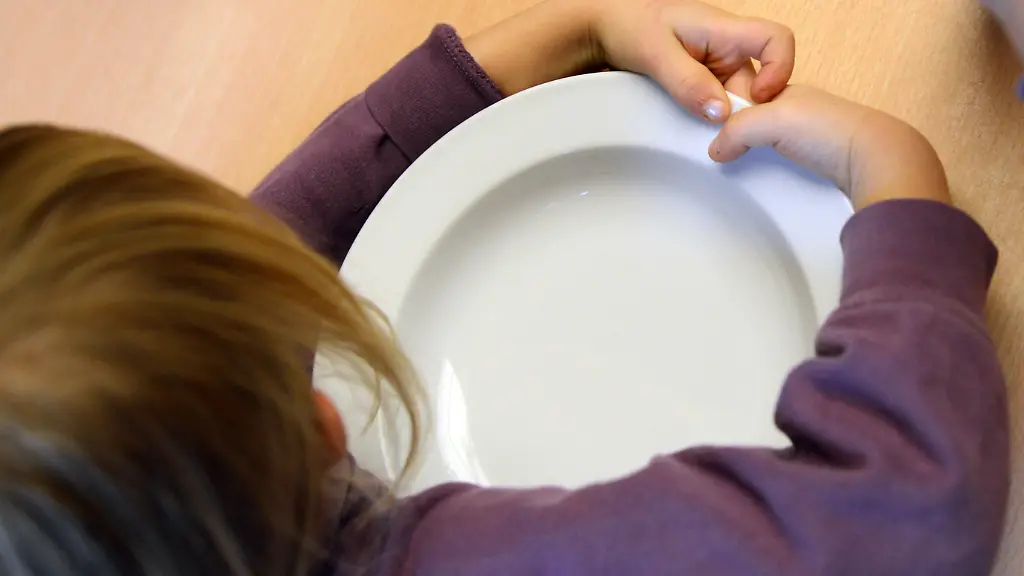 Ein-Kind-umklammert-am-30-11-2012-seinen-leeren-Teller-in-der-Kita-Treue-in-Berlin-Reinickendorf-und-wartet-auf-das-Mittagessen-Die-Einrichtung-ist-im-Wettbewerb-Packen-wir-s-an-der-Zeitschrift-selbst-ist-der-Mann-zur-Verschoenerung-von-Kindergaerten-eine-der-55-Preistraeger-Mit-dem-Projekt-wird-das-ehrenamtliche-Engagement-in-Kitas-und-Kindergaerten-unterstuetzt