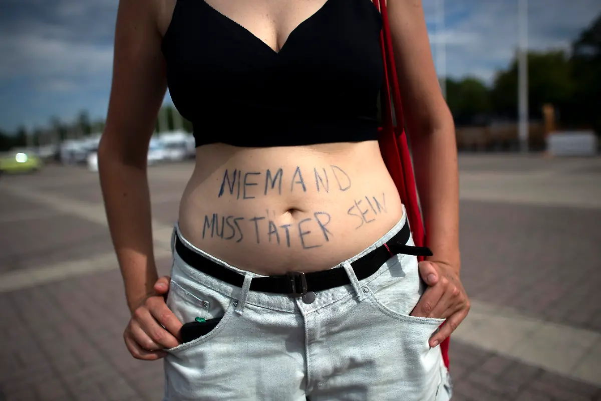DEU-Deutschland-Germany-Berlin-15-07-2023-Demonstrantin-mit-Schrift-Niemand-Muss-Taeter-Sein-auf-dem-Bauch-gegen-das-Konzert-der-Rockband-Rammstein-unter-dem-Motto-Keine-Buehne-fuer-Straftaeter-und-Kein-Rammstein-Konzert-in-Berlin-Vor-Gericht-statt-auf-die-Buehne-neben-dem-Olympiastadion-in-Berlin-Deutschland-Die-Demonstranten-fordern-die-Stadtverwaltung-auf-die-drei-Konzerte-abzusagen-nachdem-Frauen-dem-Rammstein-Saenger-Till-Lindemann-sexuelle-Uebergriffe-bei-After-Show-Partys-vorgeworfen-haben-Bei-den-Konzerten-werden-jeweils-mehr-als-60-000-Menschen-erwartet-en-Woman-Protester-with-the-writing-Nobody-Must-Be-a-Offender-on-his-stomach-against-the-concert-by-the-rock-band-Rammstein-under-the-slogan-No-Rammstein-concert-in-Berlin-next-to-the-Olympiastadion-stadium-in-Berlin-Germany-The-protesters-are-demanding-that-city-authorities-cancel-the-three-concerts-following-accusations-by-women-of-sexual-misconduct-by-Rammstein-lead-singer-Till-Lindemann