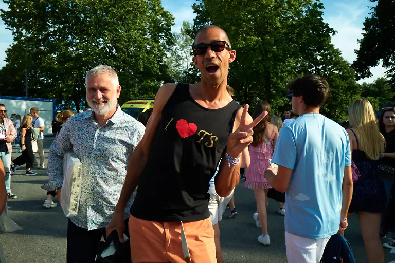 A-man-is-wearing-a-t-shirt-reading-I-love-TS-and-gesturing-in-Warsaw-Poland-on-August-3-2024-Taylor-Swift-is-performing-for-three-nights-in-a-row-in-Warsaw-as-part-of-her-Eras-Tour-which-is-also-her-first-set-of-performances-in-Poland