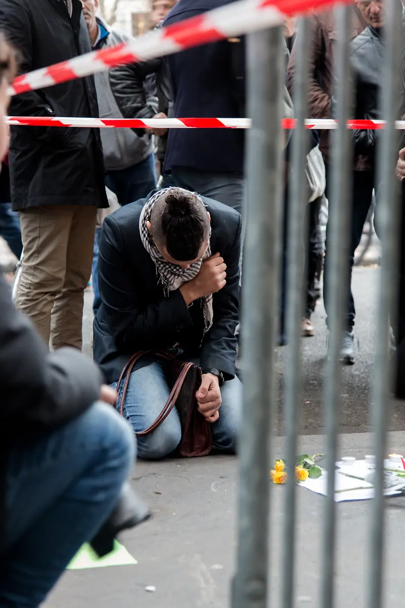 FRANCE-Paris-Large-crowds-leave-flowers-and-other-tributes-outside-the-La-Casa-Nostra-pizzeria-the-scene-of-one-of-several-deadly-terror-attacks-in-Paris-as-part-of-a-citywide-outpouring-of-grief-on-November-14-2015-At-least-129-people-were-killed-in-a-series-of-shootings-and-explosions-carried-out-the-night-before-by-the-Islamic-State-group