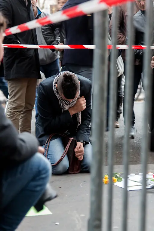 FRANCE-Paris-Large-crowds-leave-flowers-and-other-tributes-outside-the-La-Casa-Nostra-pizzeria-the-scene-of-one-of-several-deadly-terror-attacks-in-Paris-as-part-of-a-citywide-outpouring-of-grief-on-November-14-2015-At-least-129-people-were-killed-in-a-series-of-shootings-and-explosions-carried-out-the-night-before-by-the-Islamic-State-group