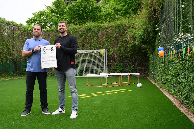 Ulf-Kirsten-l-ehemaliger-Fussball-Nationalspieler-und-sein-Sohn-Benjamin-Kirsten-ehemaliger-Torwart-der-SG-Dynamo-Dresden-stehen-waehrend-eines-Pressetermins-zur-Uebergabe-des-ersten-Bolzplatzes-der-Kirsten-Stiftung-im-Kinderhaus-Leubnitz-auf-dem-Kunstrasenplatz-Seit-Gruendung-im-Jahr-2003-unterstuetzt-die-Kirsten-Stiftung-den-Fussballnachwuchs-vor-allem-in-Sachsen