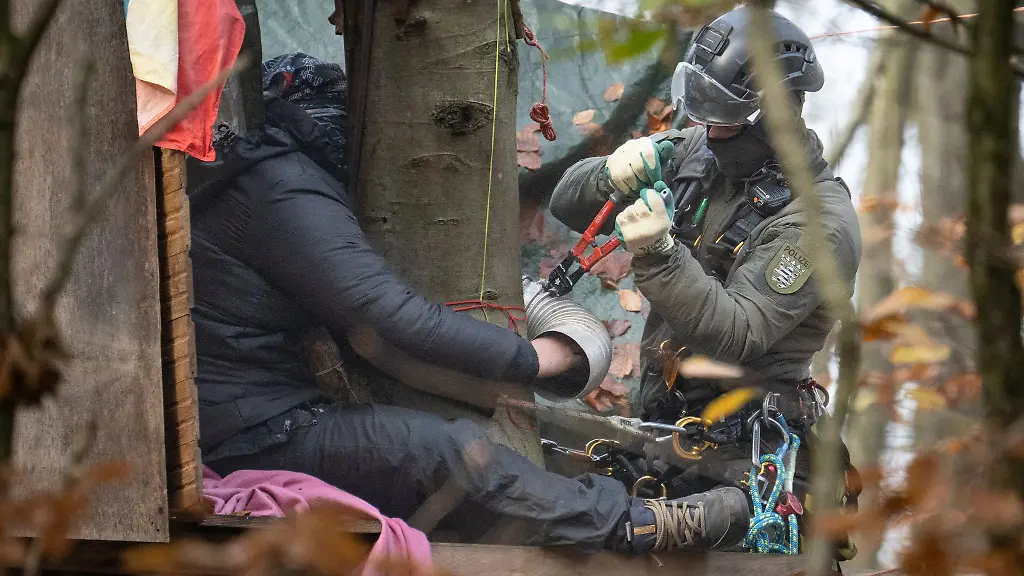 Ein-Aktivist-hat-sich-festgeklebt-ein-Beamter-des-Hoehen-Interventionsteams-loest-ihn-ab