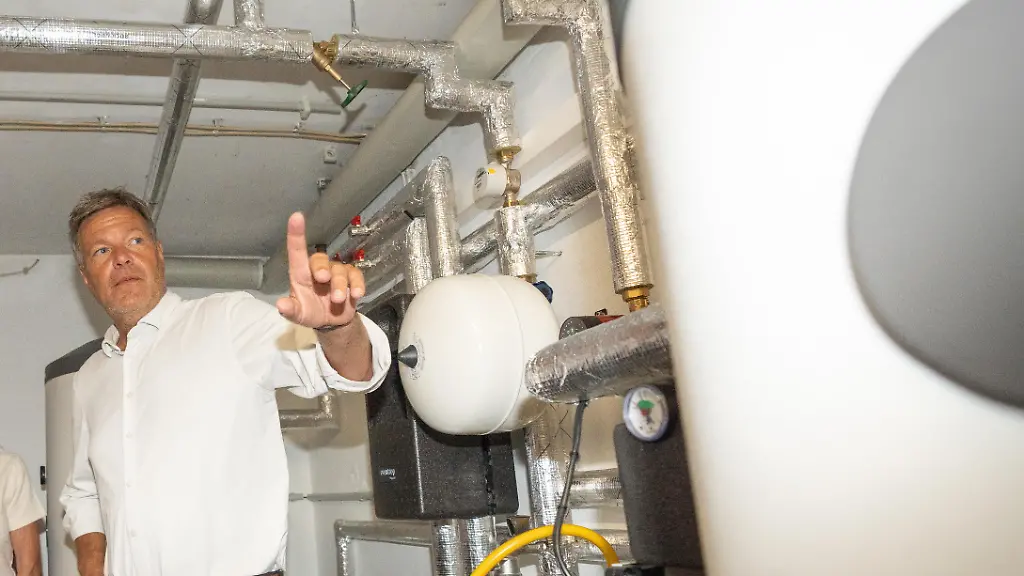 Besichtigung-Einfamilienhaus-mit-PV-Anlage-und-Erneuerbarer-Heizung-der-Firma-1KOMMA5-Der-Bundesminister-im-Gespraech-mit-der-Hauseigentuemerin-Roswitha-Mende-zu-den-Themen-Smartmeter-Waermepumpe-und-erneuerbare-Energien