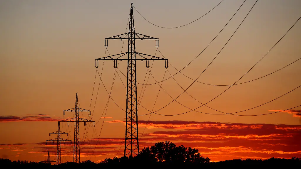 Eine-Hochspannungsleitung-zeichnet-sich-vor-dem-vom-Sonnenaufgang-verfaerbten-Morgenhimmel-ab-Auf-dem-europaeischen-Strommarkt-werden-die-Preise-zurzeit-vor-allem-von-Gaskraftwerken-vorgegeben