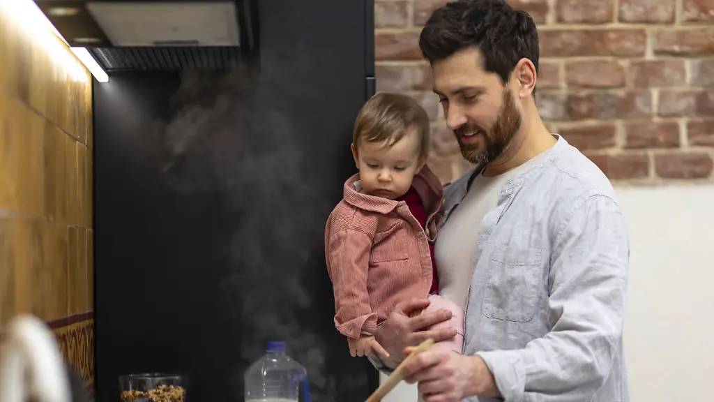 Vater-kocht-Essen-und-haelt-eine-kleine-Tochter-in-der-Kueche-und-bereitet-Suppe-zu-Father-cooking-meal-holding-toddler-daughter-in-kitchenn-preparing-soup-Copyright-imageBROKER-TYMOSHCHUKxANDRIY-ibxiqx15469053