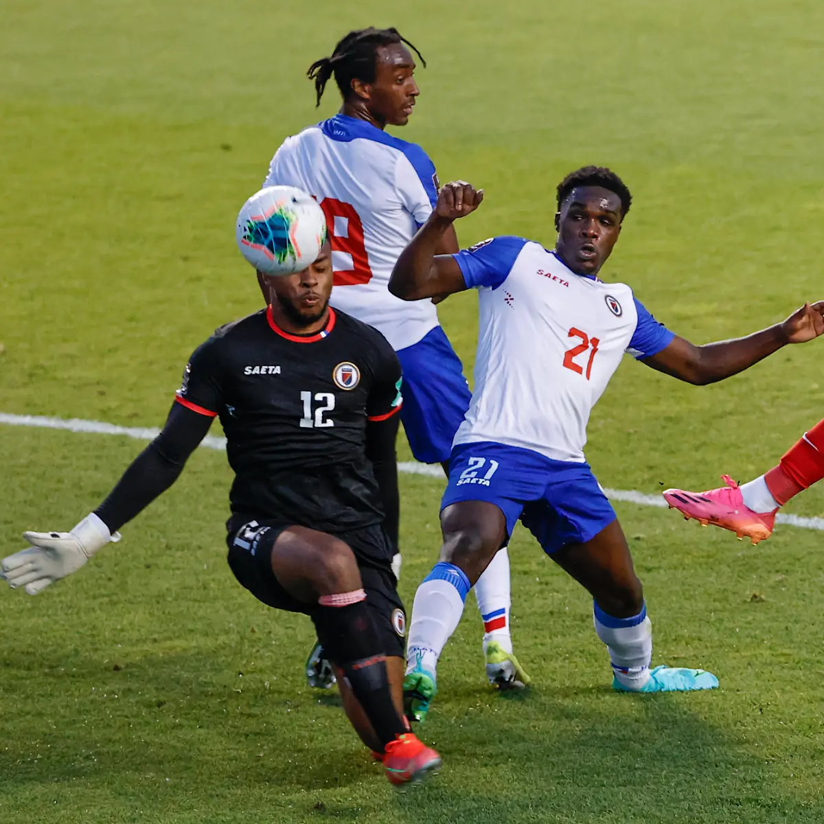 Canada-s-Jonathan-David-20-tries-to-score-against-Haiti-s-Josue-Duverger-12-and-Bryan-Alceus-21-during-the-first-half-of-a-World-Cup-qualifying-soccer-match-Tuesday-June-15-2021-in-Bridgeview-Ill