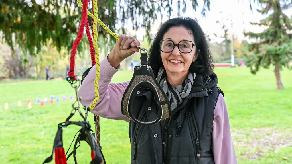 Hundetrainerin-Barbara-Gerlinger-haelt-eine-Hundeleine-in-der-Hand-Sie-leitet-einen-Kurs-fuer-Hobby-Dogging-Beim-Hobby-Dogging-tut-man-Dinge-die-man-mit-einem-Hund-tun-wuerde-nur-eben-ohne-Tier-So-geht-man-zum-Beispiel-Gassi-mit-mit-Leine-und-Halsband-aber-ohne-Hund