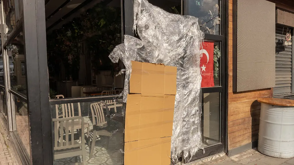 An-einem-tuerkischen-Stand-fuer-Streetfood-der-von-den-tuerkischen-Behoerden-geschlossen-wurde-haengen-eine-Pappe-und-eine-Plastikplane-neben-einer-tuerkischen-Fahne-Streetfood-beim-Istanbul-Besuch-koennte-mehreren-Mitgliedern-einer-Familie-aus-Hamburg-das-Leben-gekostet-haben-Nach-dem-Tod-der-drei-und-sechs-Jahre-alten-Kinder-ist-auch-die-Mutter-im-Krankenhaus-gestorben-wie-die-Nachrichtenagentur-DHA-berichtete-Der-Vater-werde-noch-auf-der-Intensivstation-behandelt-Im-Verdacht-steht-eine-Lebensmittelvergiftung-Ob-tatsaechlich-die-verzehrten-Speisen-die-Todesfaelle-verursacht-haben-ist-aber-unklar