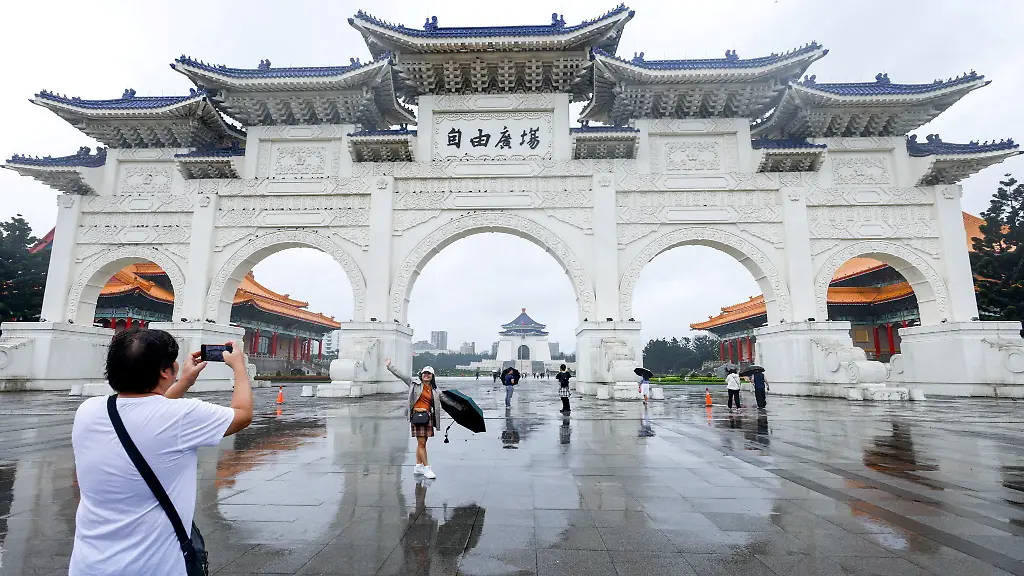 Tourists-pose-for-photos-in-front-of-the-Liberty-Square-as-Typhoon-Fung-wong-approaches-in-Taipei-Taiwan-November-11-2025
