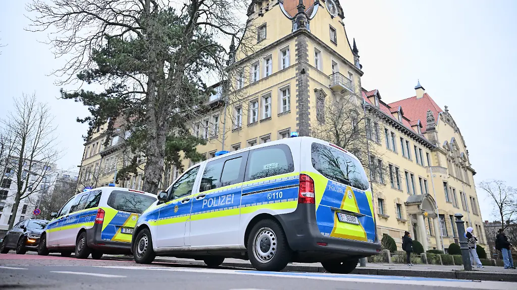 Polizeiautos-stehen-nach-einem-Reizgasaustritt-in-der-Friedrich-Bergius-Schule-vor-dem-Gebaeude-Mehrere-Schueler-und-Schuelerinnen-wurden-am-Mittag-im-Rahmen-einer-Auseinandersetzung-durch-einen-Reizstoff-wie-Pfefferspray-oder-aehnliches-verletzt-wie-die-Polizei-mitteilte