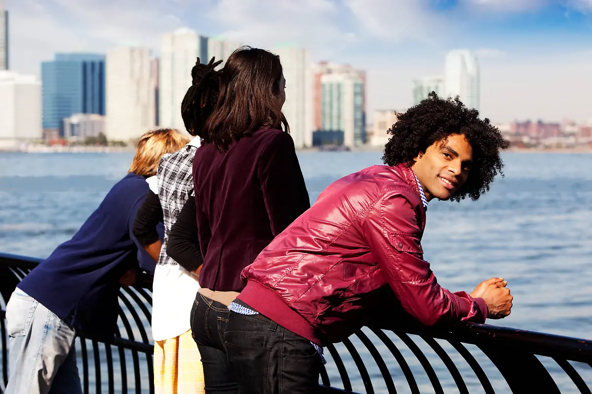 An-African-American-looking-at-the-camera-with-a-group-of-friends-in-the-background-Copyright-xTylerxOlsonx-xDesignxPicsx-30528160-PUBLICATIONxINxGERxSUIxAUTxONLY-Copyright-TylerxOlsonx-xDesignxPics-30528160