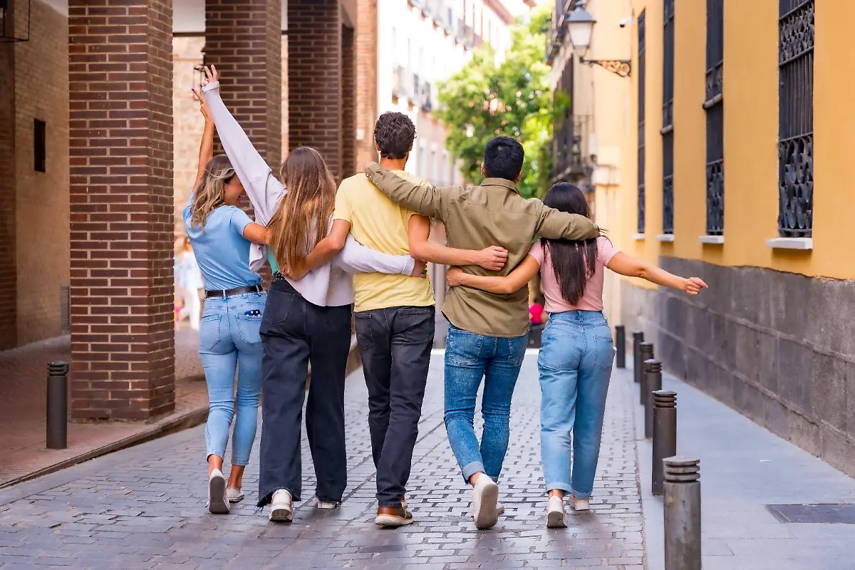 Gruppe-von-multirassischen-Freunden-die-sich-in-der-Stadt-von-hinten-umarmen-Freundschaftskonzept-mit-Jungen-und-Maedchen-Group-from-multiracial-friends-the-itself-in-the-City-from-at-the-back-hug-Friendship-Concept-with-Boys-and-Girls-Copyright-imageBROKER-UnaixHuizi-ibxuhu09450046
