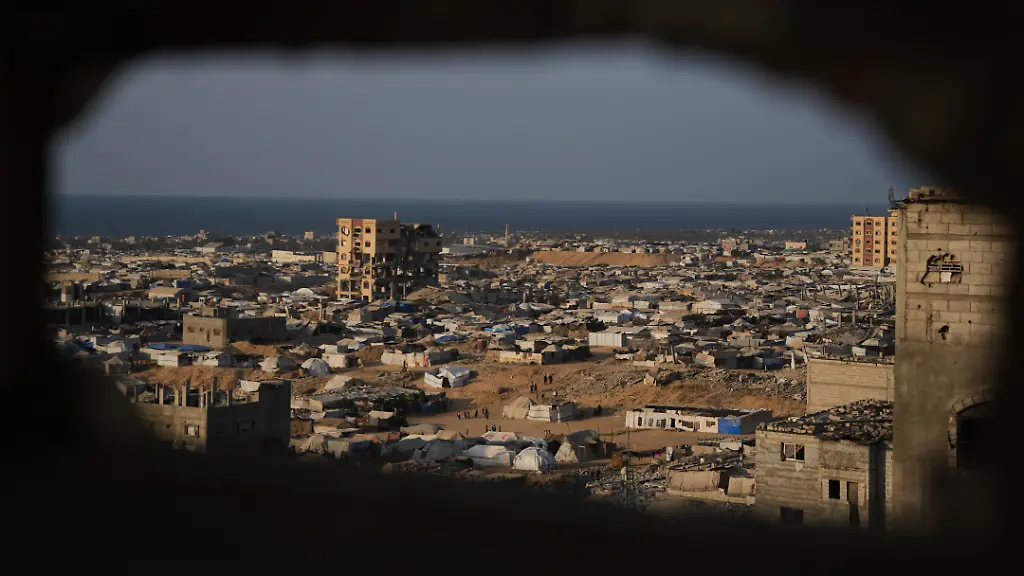 Ein-Zeltlager-fuer-vertriebene-Palaestinenser-erstreckt-sich-inmitten-der-Ruinen-zerstoerter-Gebaeude-in-Chan-Junis-im-suedlichen-Gazastreifen