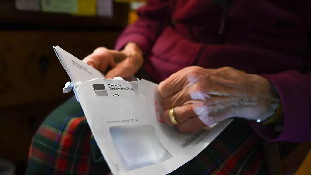 Eine-Seniorin-haelt-ihren-Rentenbescheid-in-der-Hand-Schlechten-Nachrichten-gibt-es-fuer-die-Rentner-in-Westdeutschland-Ihre-Renten-werden-nach-den-Prognosen-der-Deutschen-Rentenversicherung-2021-nicht-steigen-Lediglich-im-Osten-sei-im-Zuge-der-Rentenangleichung-zwischen-Ost-und-West-noch-mit-einem-kleinen-Plus-zu-rechnen