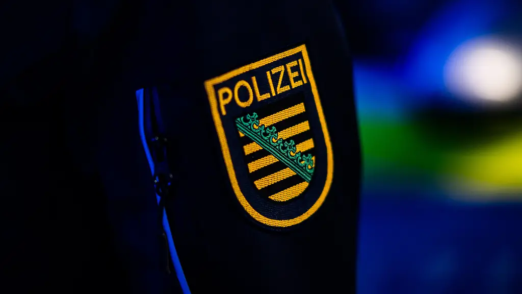 Ein-Polizist-steht-neben-einem-Polizeiauto