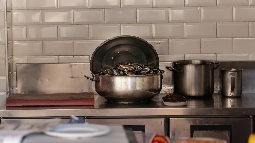 In-einem-tuerkischen-Stand-fuer-Streetfood-der-von-den-tuerkischen-Behoerden-geschlossen-wurde-steht-noch-ein-Topf-mit-Muscheln-Streetfood-beim-Istanbul-Besuch-koennte-mehreren-Mitgliedern-einer-Familie-aus-Hamburg-das-Leben-gekostet-haben-Nach-dem-Tod-der-drei-und-sechs-Jahre-alten-Kinder-ist-auch-die-Mutter-im-Krankenhaus-gestorben-wie-die-Nachrichtenagentur-DHA-berichtete-Der-Vater-werde-noch-auf-der-Intensivstation-behandelt-Im-Verdacht-steht-eine-Lebensmittelvergiftung-Ob-tatsaechlich-die-verzehrten-Speisen-die-Todesfaelle-verursacht-haben-ist-aber-unklar