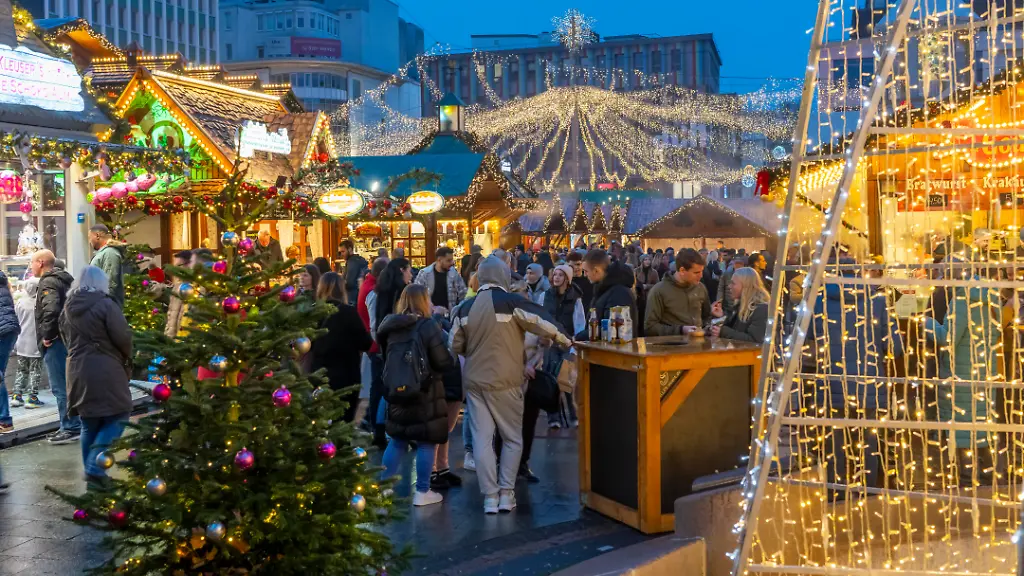 Vorweihnachtszeit-Besucher-auf-de-Weihnachtsmarkt-in-der-Innenstadt-von-Essen-auf-dem-Kennedyplatz-der-Markt-oeffnet-schon-Mitte-November-Weihnachtsbeleuchtung-Essener-Lichtwochen-NRW-Deutschland