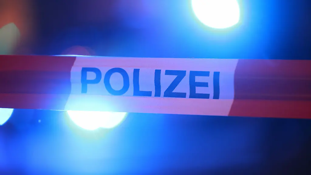 Blaulichter-leuchten-hinter-einem-Absperrband-der-Polizei