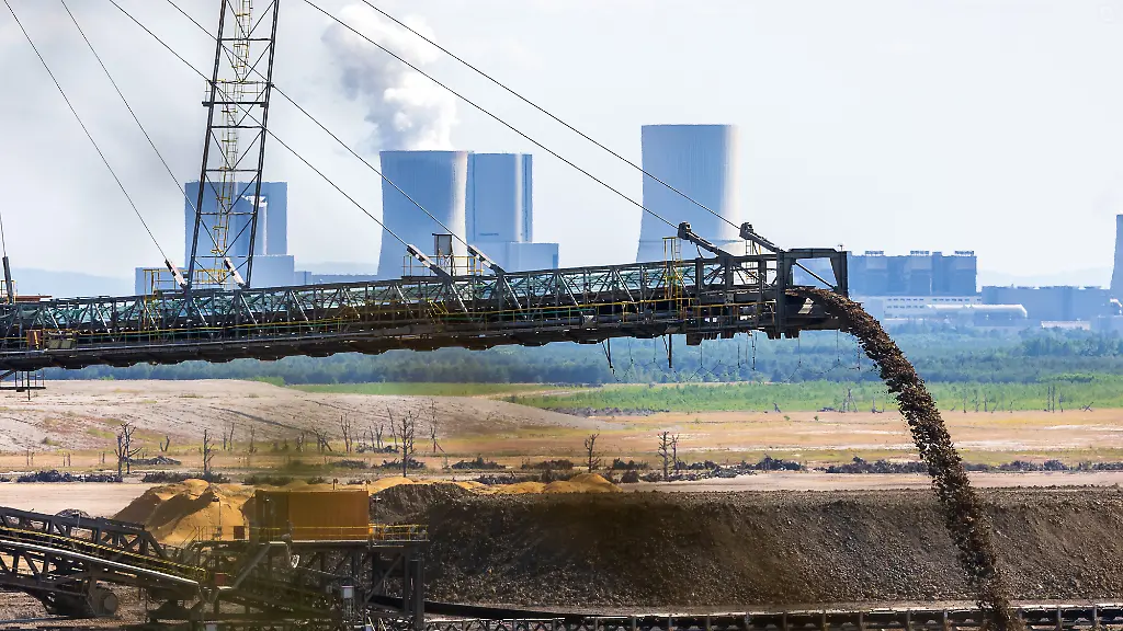 Nahaufnahme-eines-Abraumfoerderbandes-im-Braunkohletagebau-Nochten-mit-Blick-auf-das-Braunkohlekraftwerk-Boxberg-im-Hintergrund-Der-Foerderstrom-faellt-in-eine-Abbaugrube-waehrend-die-markanten-Kuehltuerme-des-Kraftwerks-der-LEAG-mit-aufsteigendem-Wasserdampf-im-Hintergrund-sichtbar-sind-Die-Aufnahme-zeigt-die-direkte-raeumliche-Verbindung-zwischen-Tagebau-und-Stromerzeugung-in-der-Oberlausitz-Sachsen-Deutschland-LEAG-Braunkohletagebau-Nochten-und-Kraftwerk-Boxberg-Oberlausitz-20-06
