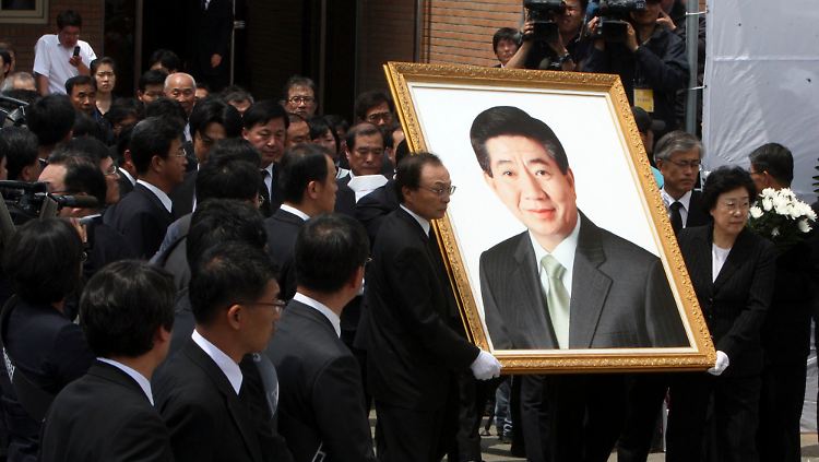 Bei der Trauerfeier tragen die früheren südkoreanischen Premierminister Lee Hae-chan (l.) und Han Myung-suk ein Porträt von Roh Moo-hyun.