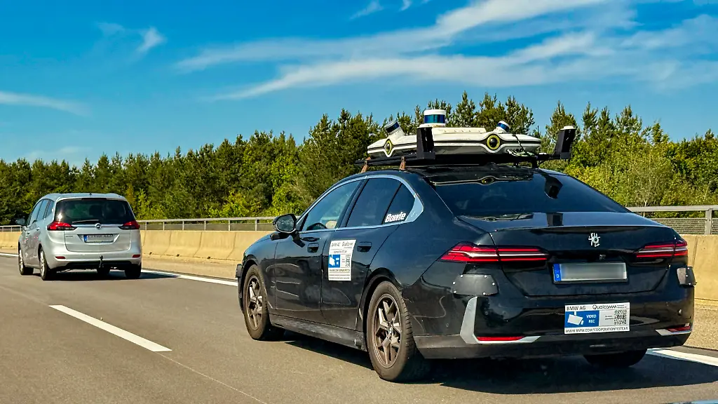 11-08-2025-Autobahn-A96-bei-Muenchen-Leicht-getarnter-Testwagen-der-BMW-AG-in-Zusammenarbeit-mit-Qualcomm-fuer-Autonomes-Fahren-mit-aufwaendiger-Sensorik-auf-dem-Dach-und-an-der-Karosserie-auf-der-Strasse-BMW-moechte-den-Fahrzeugkomfort-durch-die-Einfuehrung-neuer-Technologien-zur-Weiterentwicklung-der-assistierten-vernetzten-teil-automatisierten-und-autonomen-Fahrzeugkomfortfunktionen-weiterentwickeln-und-dadurch-ein-verbessertes-Fahrerlebnis-bieten-Die-Testfahrzeuge-sind-mit-verschiedenen-Sensoren-wie-Radar-Ultraschall-GPS-Ortungssensoren-Innenraum-Mikrofonen-und-Videokameras-ausgeruestet-Der-oeffentliche-Strassenverkehr-Umgebung-des-Testfahrzeugs-kann-auf-Video-aufgezeichnet-werden