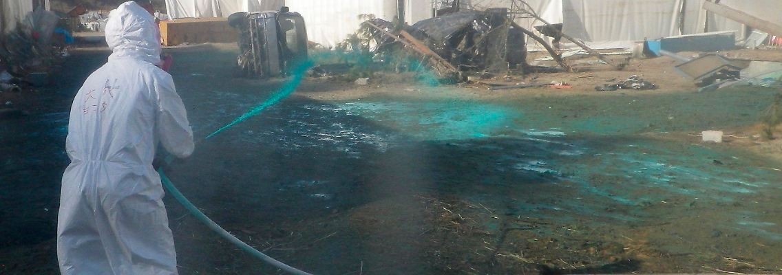 Arbeiter in Fukushima versuchen, den Staub am Boden zu binden.