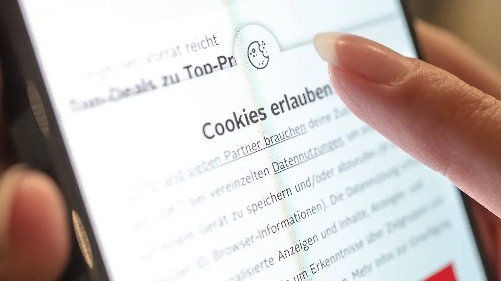 Eine-Person-hat-ein-Handy-in-der-Hand-auf-dem-sie-auf-einer-Internetseite-im-Browser-nach-der-Zustimmung-von-Cookies-gefragt-wird