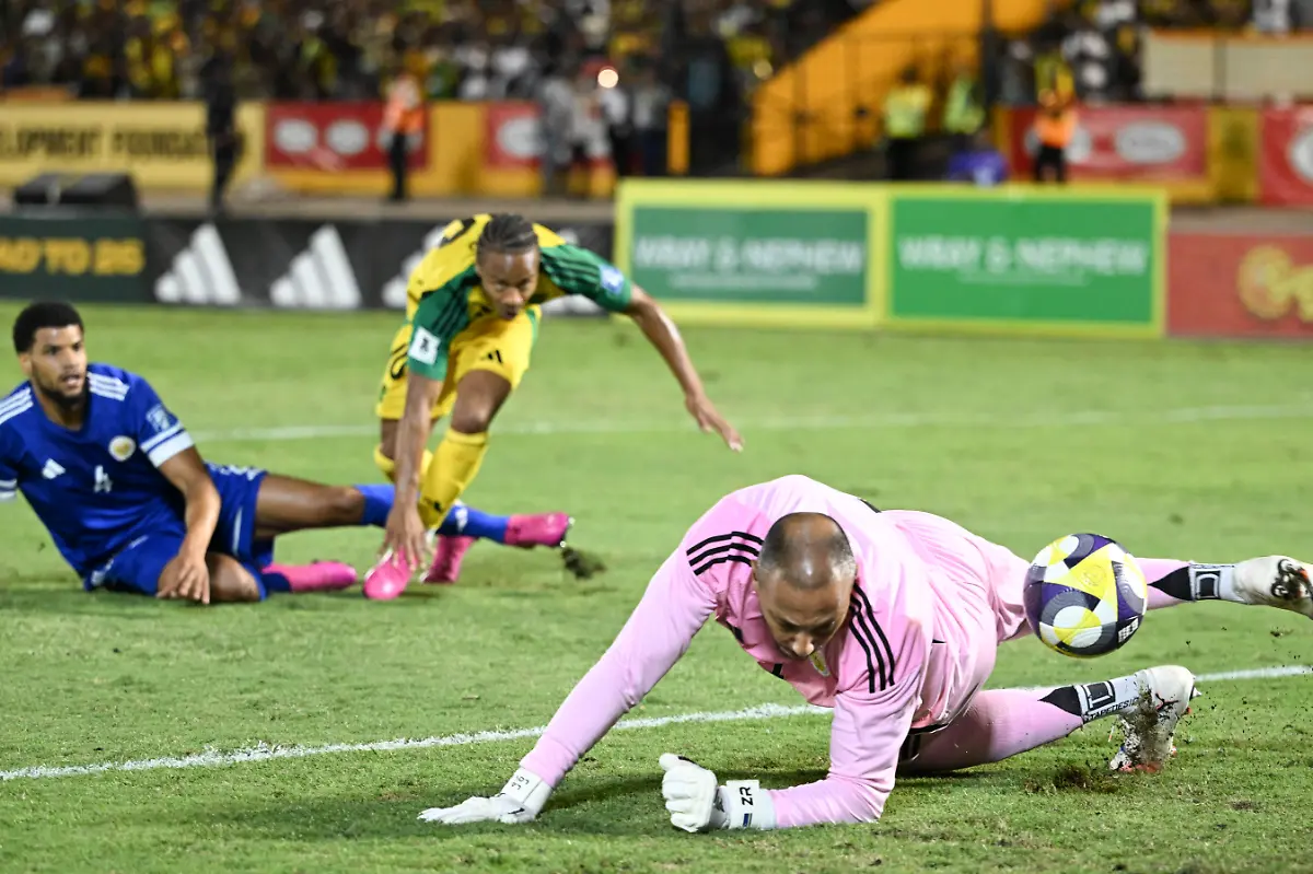 Curacao-s-goalkepper-01-Eloy-Room-R-makes-a-save-in-a-scoring-attempt-by-Jamaica-s-forward-10-Bobby-Reid-C-during-the-World-Cup-qualifier-football-match-between-Jamaica-and-Curacao-at-the-National-Stadium-in-Kingston-Jamaica-on-November-18-2025