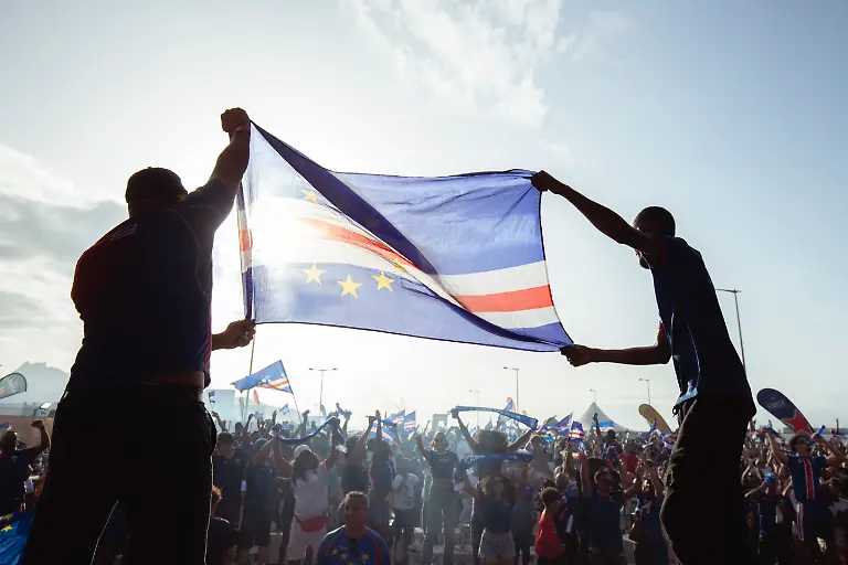 Supporters-celebrate-Cape-Verdes-victory-against-Eswatini-during-the-FIFA-World-Cup-2026-Africa-qualifiers-group-D-match-at-a-fan-zone-in-Sao-Vicente-Cape-Verde-on-October-13-2025-A-carnival-like-atmosphere-erupted-in-the-streets-of-Cape-Verde-on-Monday-after-the-tiny-archipelago-nation-qualified-for-the-first-time-ever-for-the-World-Cup-Located-off-the-coast-of-Senegal-it-is-the-country-with-the-smallest-population-to-represent-Africa-in-the-global-showpiece-with-just-550-000-inhabitants