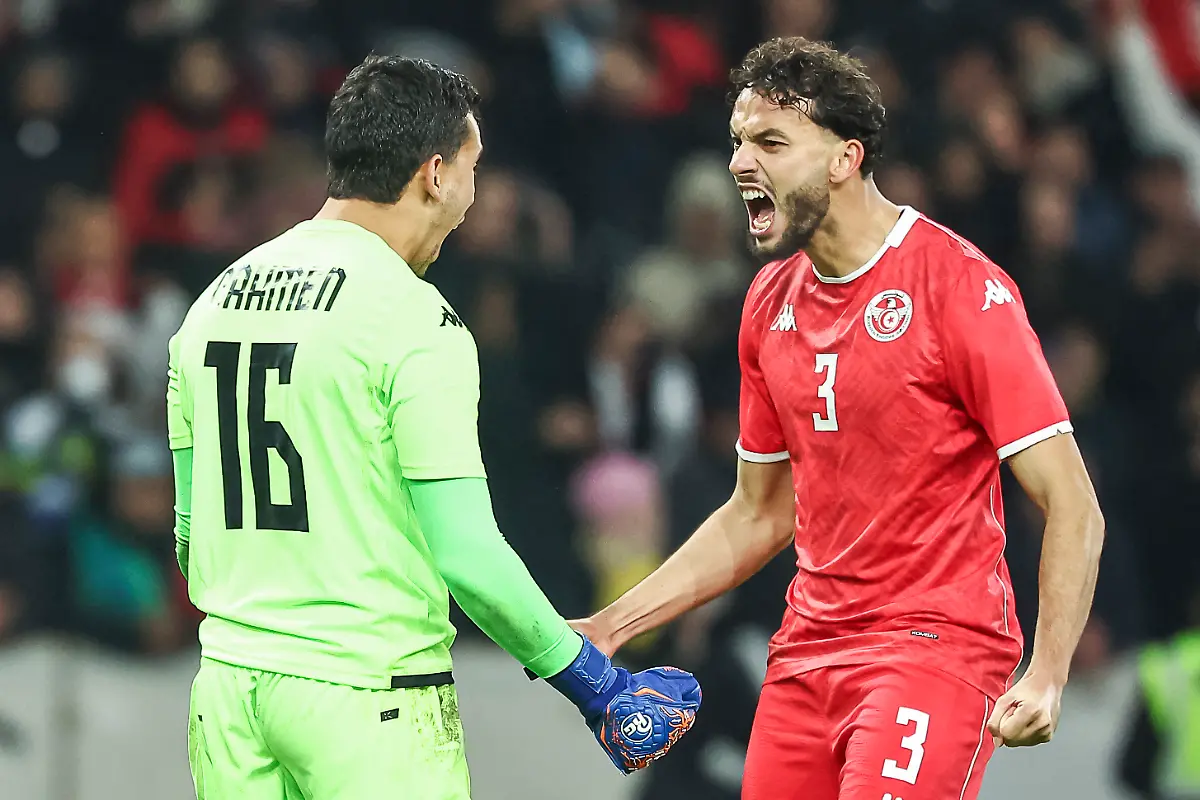 Tunisia-s-goalkeeper-16-Aymen-Dahmen-L-celebrates-with-Tunisia-s-defender-03-Montassar-Talbi-R-after-saving-a-penalty-kick-during-the-International-friendly-football-match-between-Brazil-and-Tunisia-at-Stade-Pierre-Mauroy-in-Villeneuve-d-Ascq-northern-France-on-November-18-2025