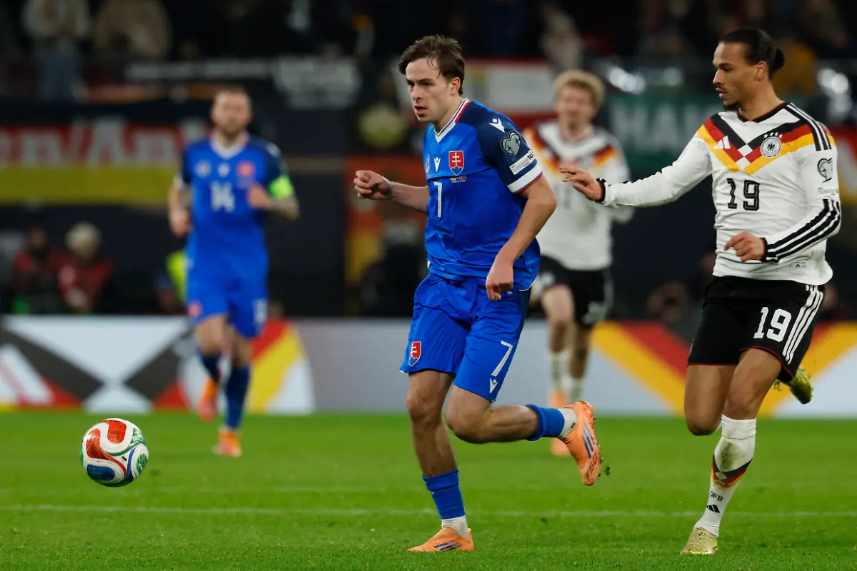 Slovakia-s-forward-07-Leo-Sauer-and-Germany-s-midfielder-19-Leroy-Sane-vie-for-the-ball-during-the-FIFA-World-Cup-2026-European-qualification-Group-A-football-match-between-Germany-and-Slovakia-in-Leipzig-eastern-Germany-on-November-17-2025