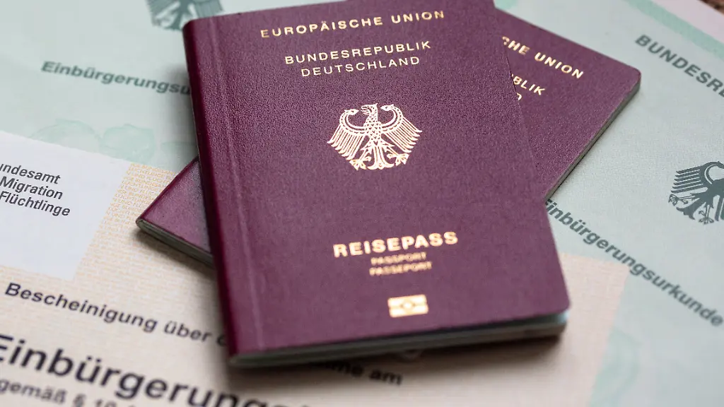 Zwei-deutsche-Reisepaesse-liegen-auf-Einbuergerungsurkunden-der-Bundesrepublik-Deutschland-sowie-einem-Einbuergerungstest-Die-von-der-Ampel-Koalition-eingefuehrte-Turbo-Einbuergerung-fuer-besonders-gut-integrierte-Auslaender-wird-heute-voraussichtlich-wieder-abgeschafft