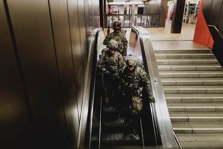 Drei-Soldaten-fahren-mit-einer-Rolltreppe-in-einer-U-Bahnstation-aufgenommen-im-Rahmen-der-Bundeswehr-Uebung-Operation-Bollwerk-Baerlin-in-Berlin-19-11-2025-Waehrend-des-Uebungsszenarios-des-Wachbataillon-der-Bundeswehr-sollen-Saboteure-einer-U-Bahn-im-Uebungstunnel-Jungfernheide-festgesetzt-sowie-verletzte-Soldaten-geborgen-und-versorgt-werden